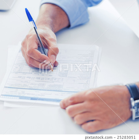 man filling tax form 25283051