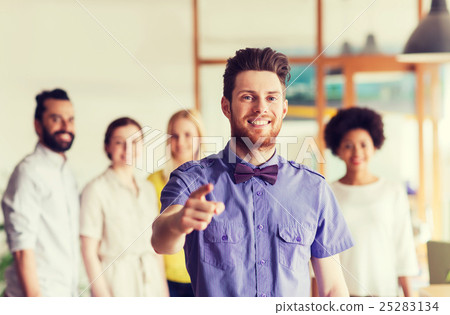 happy man pointing finger at you over office team 25283134