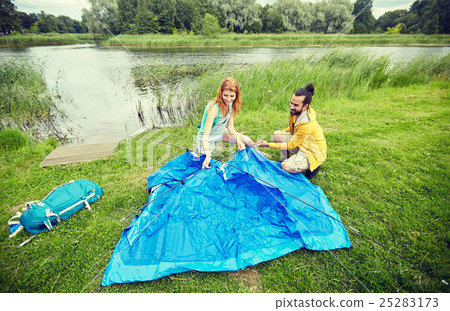 happy couple setting up tent outdoors happy couple setting up tent outdoors 25283173