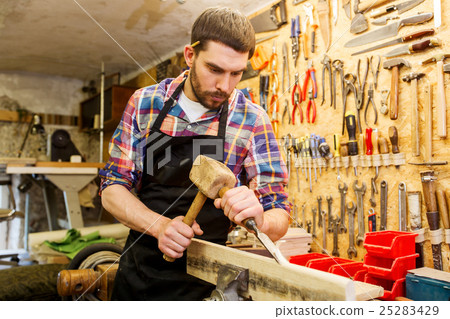 carpenter with wood, hammer and chisel at workshop carpenter with wood, hammer and chisel at workshop 25283429