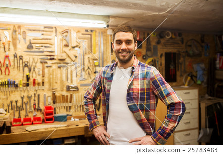 happy young workman in checkered shirt at workshop happy young workman in checkered shirt at workshop 25283483