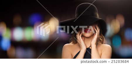 beautiful woman in black hat over night lights 25283684