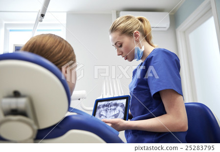dentist showing x-ray on tablet pc to patient girl 25283795