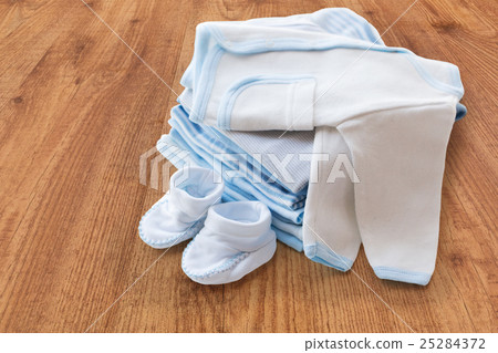 close up of baby boys clothes for newborn on table close up of baby boys clothes for newborn on table 25284372