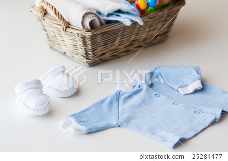 close up of baby clothes for newborn boy in basket 25284477