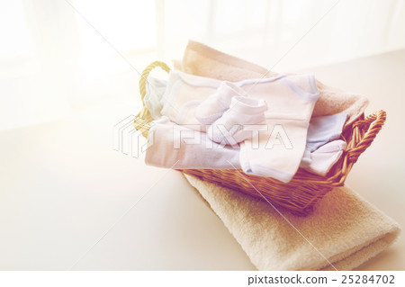 close up of baby clothes for newborn boy in basket 25284702