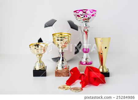close up of football ball, golden cups and medals 25284986