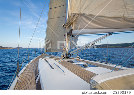 Sailing boat teak deck and hoisted sails, view 25290379
