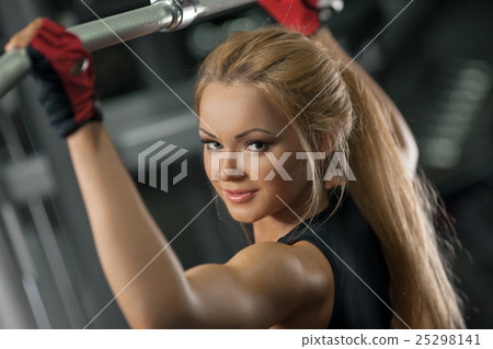 Brutal athletic woman doing back pullups at the 25298141