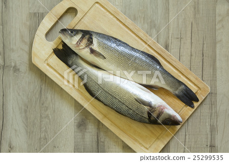 Whole seabass on a wooden board Whole seabass on a wooden board 25299535