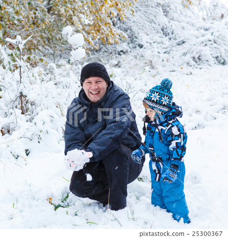 Happy child and dad having fun with snow in winter Happy child and dad having fun with snow in winter 25300367