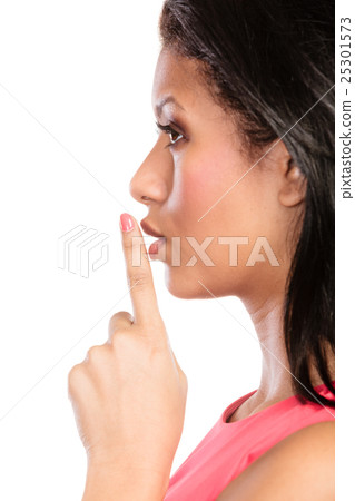 Woman with finger on lips showing silence gesture. 25301573