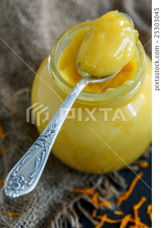 Jar with lemon custard and a teaspoon. Jar with lemon custard and a teaspoon. 25303045