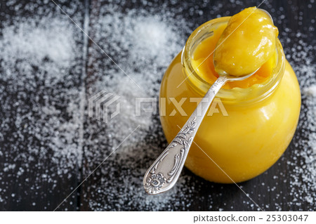 Lemon custard in a teaspoon and glass jar. Lemon custard in a teaspoon and glass jar. 25303047
