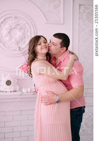 Family waiting for baby's birth. A pregnant woman and her husband wearing white clothing 25305566