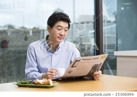 Middleaged Asian Man Reading Newspaper and Having Coffee at Home in the Morning Middleaged Asian Man Reading Newspaper and Having Coffee at Home in the Morning 25306994