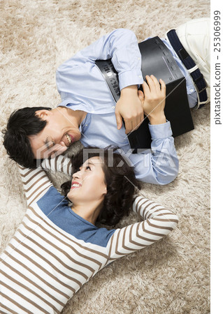 Middleaged Asian Couple Lying Down on Rug 25306999