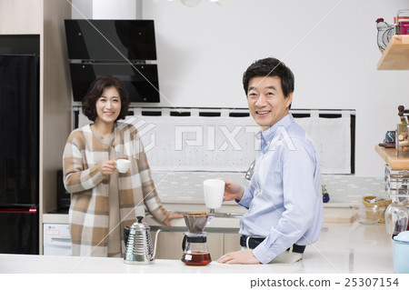 Middleaged Asian Couple Having Coffee in Kitchen 25307154