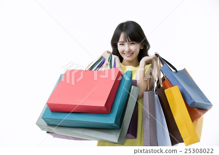 A young woman carrying a bunch of shopping bags A young woman carrying a bunch of shopping bags 25308022