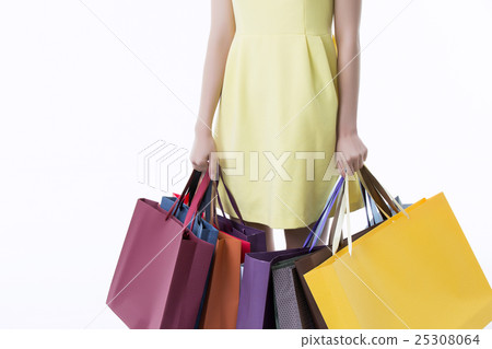 A young woman carrying a bunch of shopping bags A young woman carrying a bunch of shopping bags 25308064