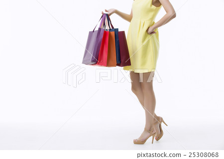 A young woman carrying a bunch of shopping bags A young woman carrying a bunch of shopping bags 25308068