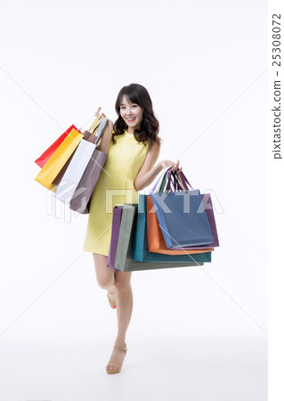 A young woman carrying a bunch of shopping bags A young woman carrying a bunch of shopping bags 25308072