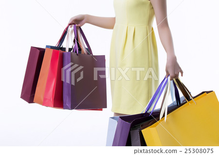 A young woman carrying a bunch of shopping bags A young woman carrying a bunch of shopping bags 25308075
