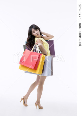 A young woman carrying a bunch of shopping bags A young woman carrying a bunch of shopping bags 25308080