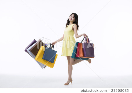 A young woman carrying a bunch of shopping bags A young woman carrying a bunch of shopping bags 25308085