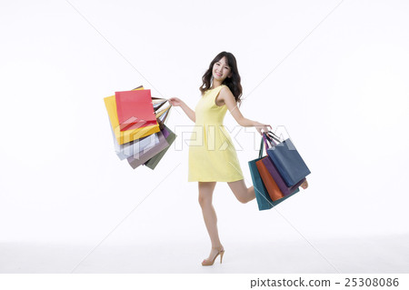 A young woman carrying a bunch of shopping bags A young woman carrying a bunch of shopping bags 25308086