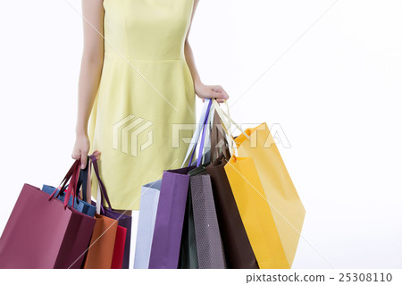 A young woman carrying a bunch of shopping bags A young woman carrying a bunch of shopping bags 25308110