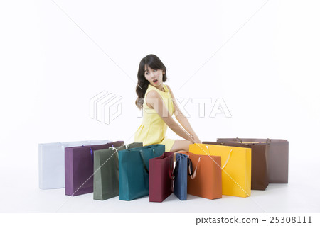 A young woman carrying a bunch of shopping bags A young woman carrying a bunch of shopping bags 25308111