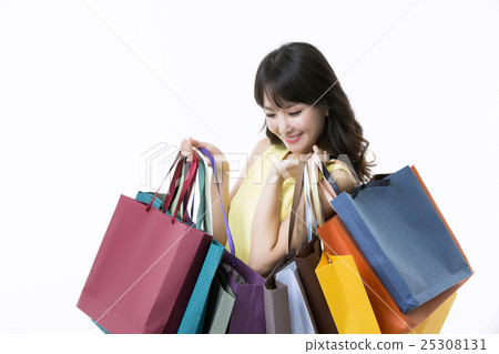 A young woman carrying a bunch of shopping bags 25308131