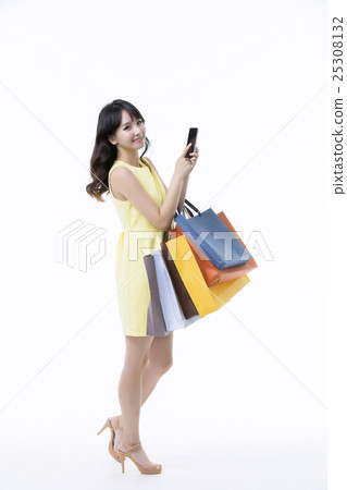 A young woman carrying a bunch of shopping bags 25308132