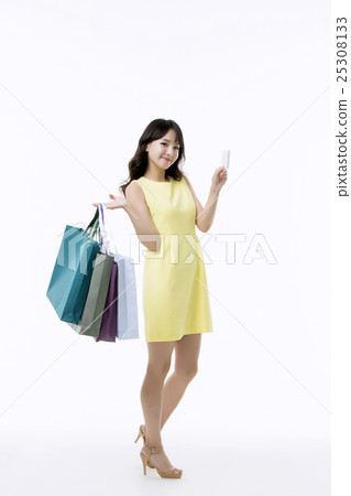 A young woman carrying a bunch of shopping bags 25308133