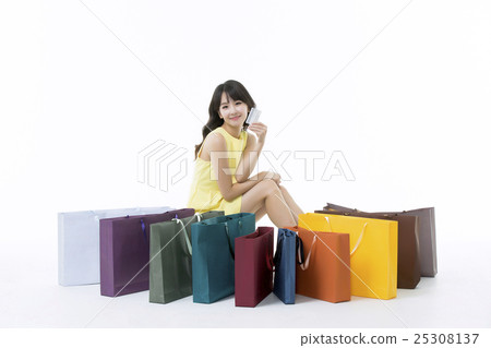A young woman carrying a bunch of shopping bags A young woman carrying a bunch of shopping bags 25308137