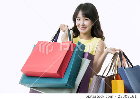 A young woman carrying a bunch of shopping bags A young woman carrying a bunch of shopping bags 25308161