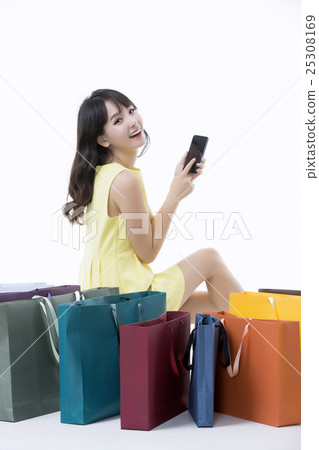 A young woman carrying a bunch of shopping bags 25308169