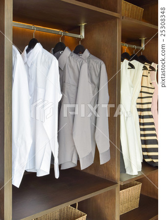 white and gray shirts hanging in wooden wardrobe 25308348