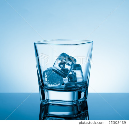 empty glass of whiskey on black table with reflection and ice on light blue tint background empty glass of whiskey on black table with reflection and ice on light blue tint background 25308489
