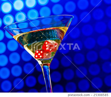 red dice in the cocktail glass on blue bokeh red dice in the cocktail glass on blue bokeh 25308585