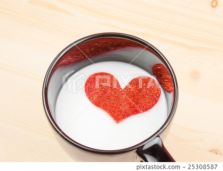 cup of milk with decorative heart on wood table, concept of valentine day 25308587