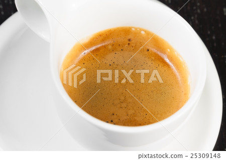 great italian coffee in a white cup on black wood table great italian coffee in a white cup on black wood table 25309148
