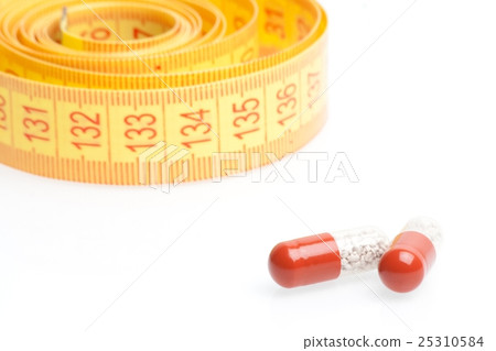 medical pills for dieting in front of measuring tape medical pills for dieting in front of measuring tape 25310584