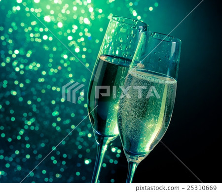 champagne flutes with golden bubbles on dark green light bokeh background champagne flutes with golden bubbles on dark green light bokeh background 25310669
