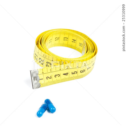 medical blue pills in front of measure tape, concept for diet 25310999