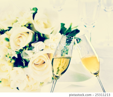 champagne flutes with golden bubbles on wedding flowers background champagne flutes with golden bubbles on wedding flowers background 25311213