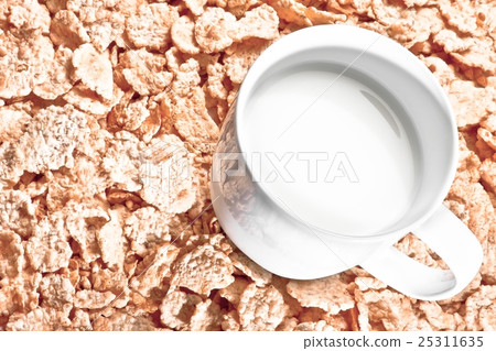 top of view of cup of milk on corn flakes, diet concept top of view of cup of milk on corn flakes, diet concept 25311635