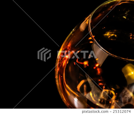 top of view of snifter of brandy in elegant typical cognac glass on black background with red reflection top of view of snifter of brandy in elegant typical cognac glass on black background with red reflection 25312074