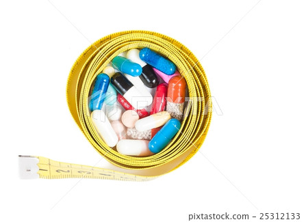 top of view of medical blue pills in front of measure tape, concept for diet 25312133